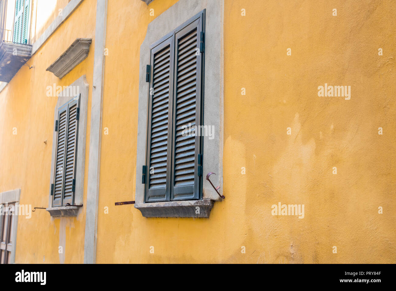 Gelbe Wände, grüne Fensterläden aus Holz, traditionelle italienische Architektur Details, Vico Equense Italien, Europa, Altstadt Konzept heißen Sommer Stockfoto