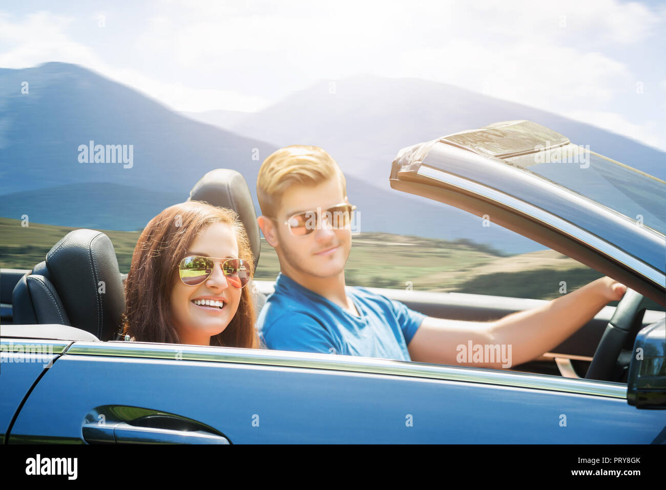 Junges Paar mit Sonnenbrille genießen Fahrt in einem Auto Stockfoto
