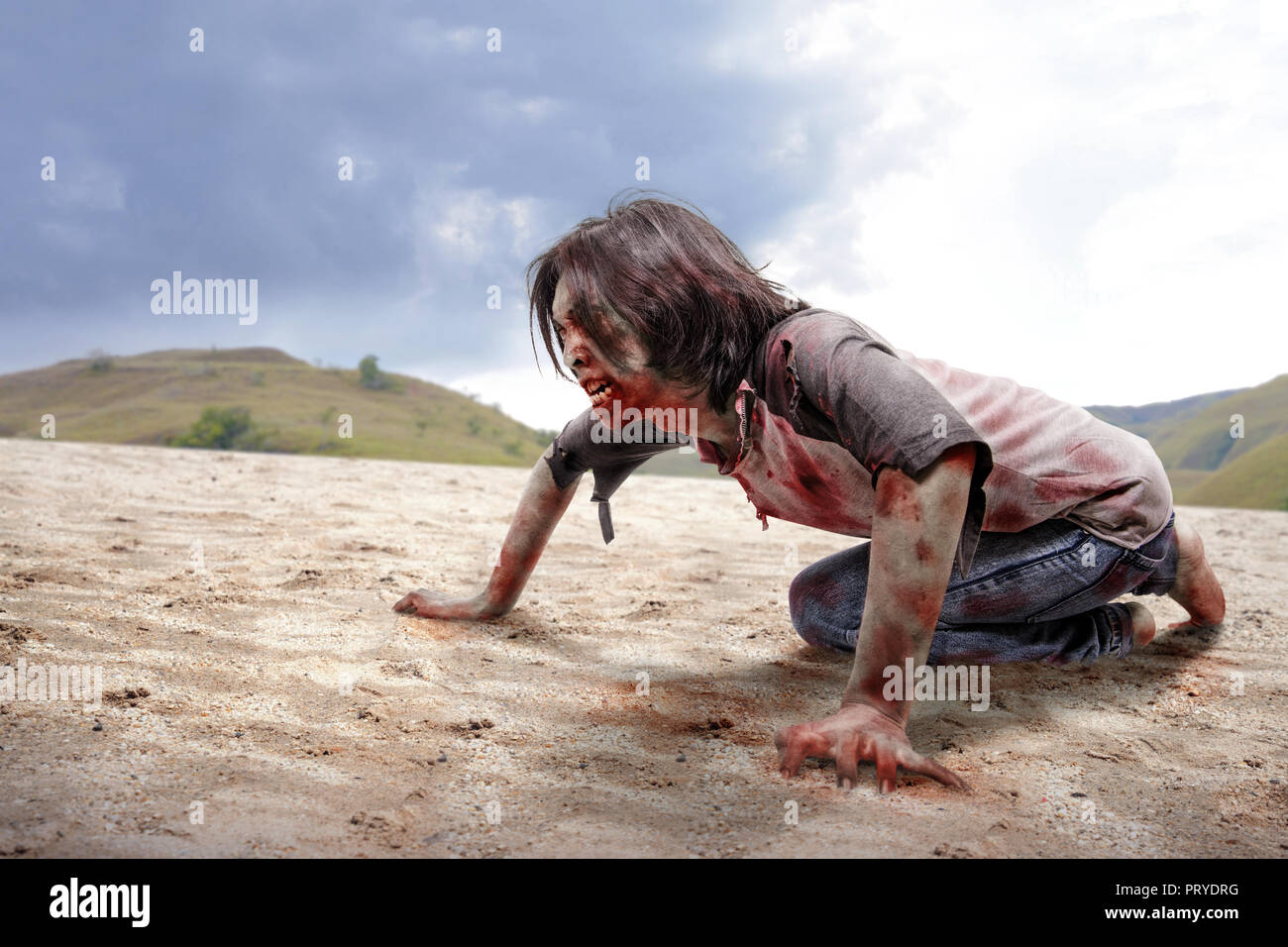 Wütende zombie Mann kriecht mit Händen und Knien auf dem Sand dune Stockfoto