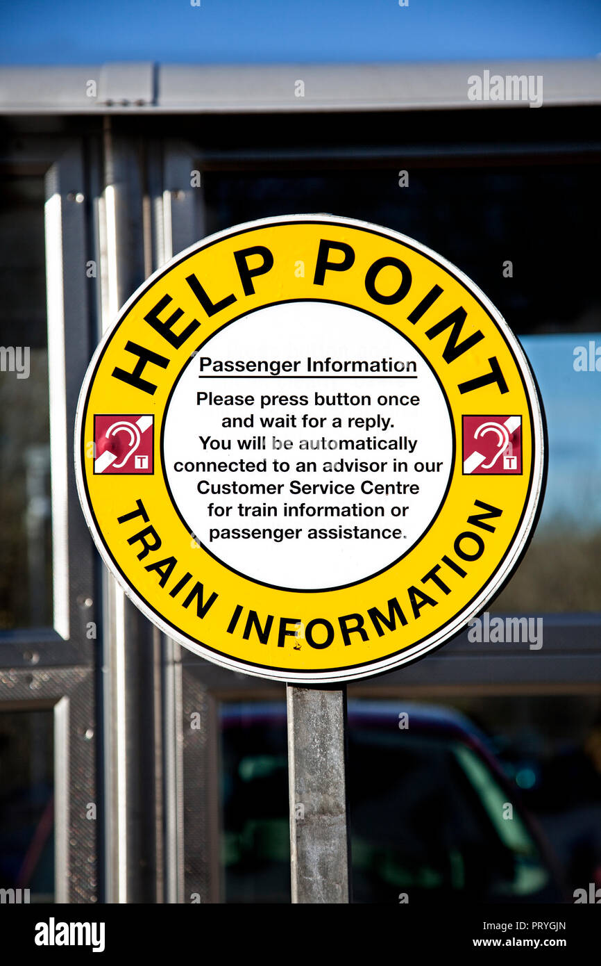 Zeichen über eine Hilfe bei einem unbemannten Bahnhof in Scoltand, Großbritannien, mit einem Symbol, das Hörgerät Zugang für hörgeschädigte Kunden. Stockfoto