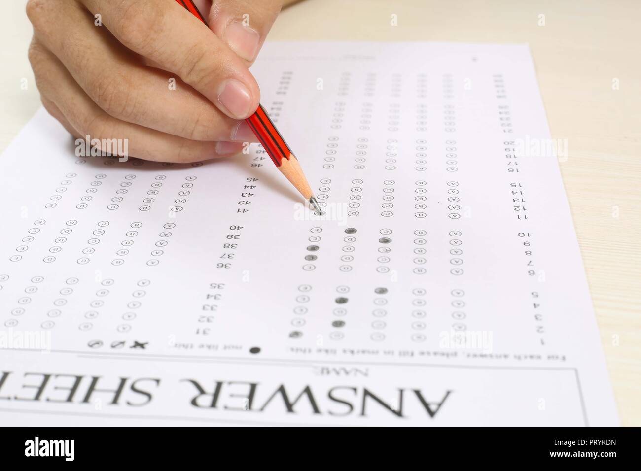 Bild des Menschen füllen OME-Blatt mit Bleistift in der Hand. Auf weissem Hintergrund. Stockfoto