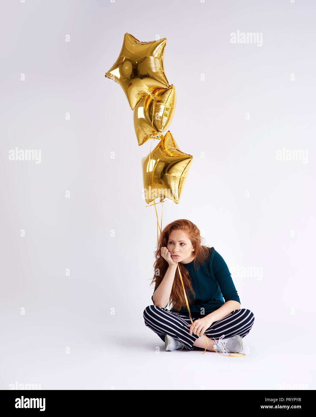 Porträt der jungen Frau mit drei golden star-förmige Ballons Stockfoto