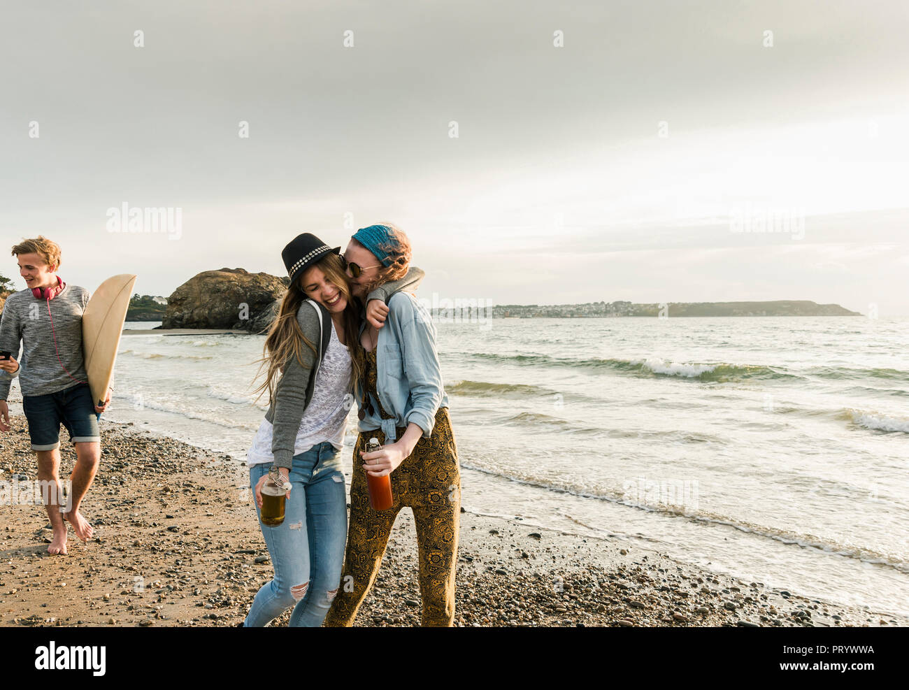 Gerne Freunde mit Getränken umarmen am Strand Stockfoto