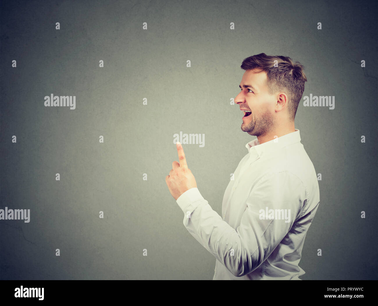 Eureka! Young Business Mann mit einem Finger nach oben hat eine Idee auf grauem Hintergrund Stockfoto