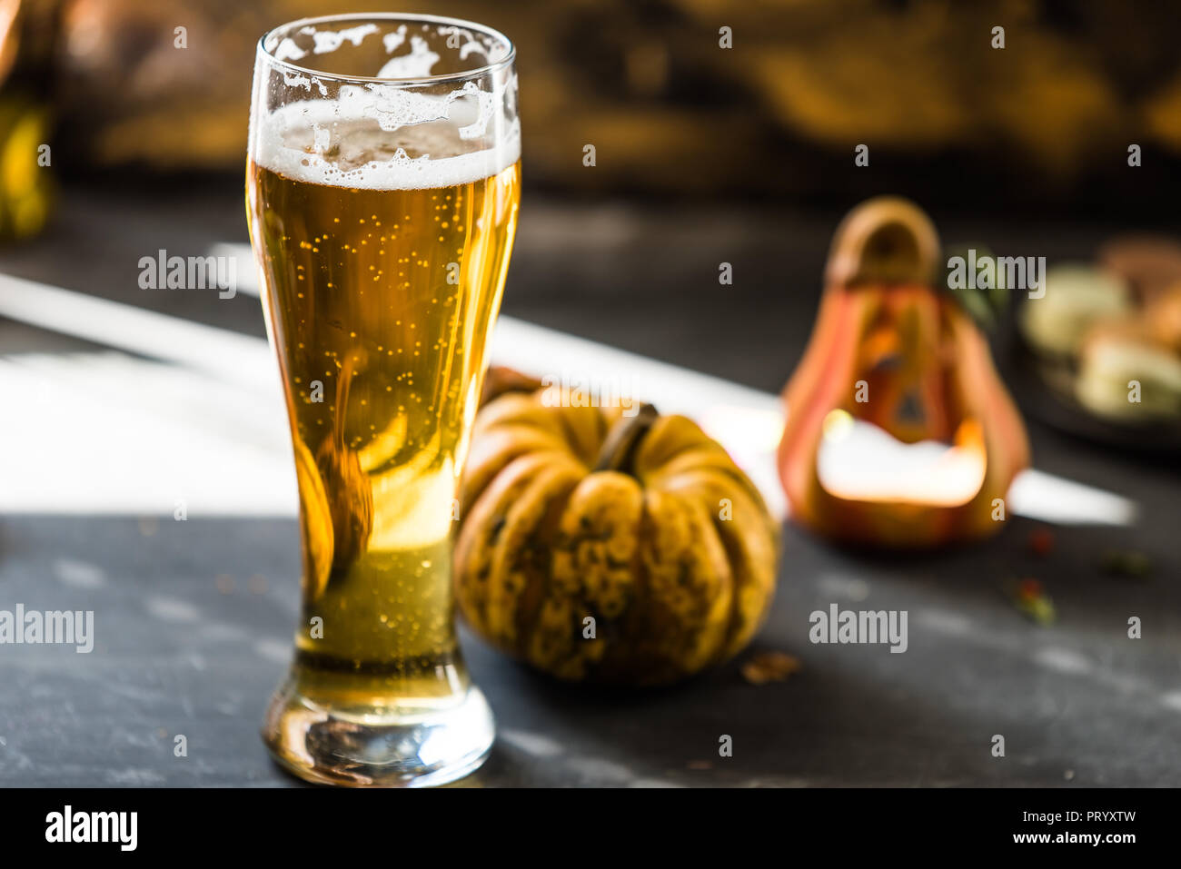 Glas goldenen Bier auf dunklen, hölzernen Tisch, bis Herbst Dekorationen umgeben Stockfoto