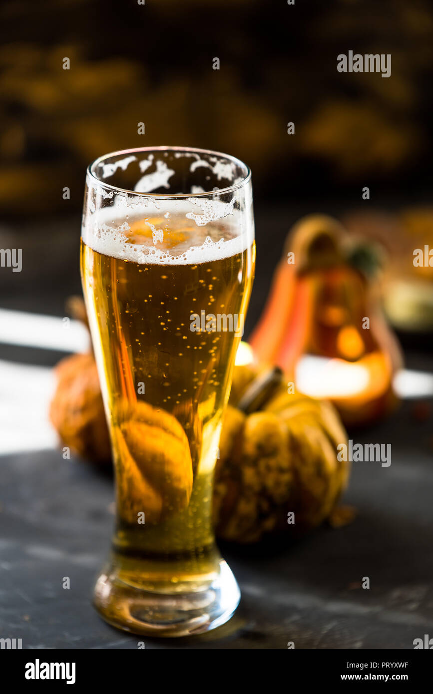 Glas goldenen Bier auf dunklen, hölzernen Tisch, bis Herbst Dekorationen umgeben Stockfoto