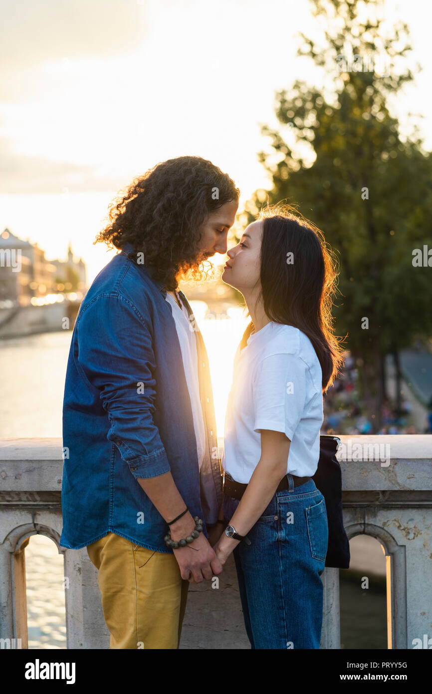 Frankreich, Paris, zärtlich junges Paar an Seine bei Sonnenuntergang Stockfoto