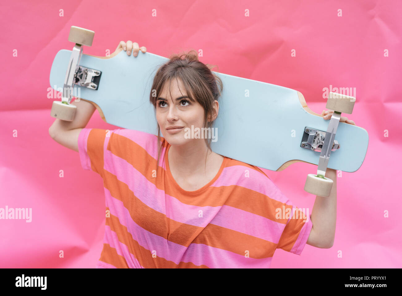 Frau mit Skateboard, Suchen nach Stockfoto
