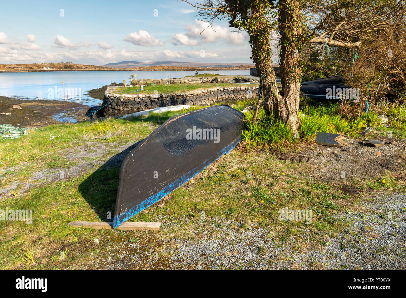 Roundstone, Connemara, Galway, Irland, 04/2018, heruntergekommene Fischerboote links nach Verfall neben der Bucht von Connemara. Stockfoto