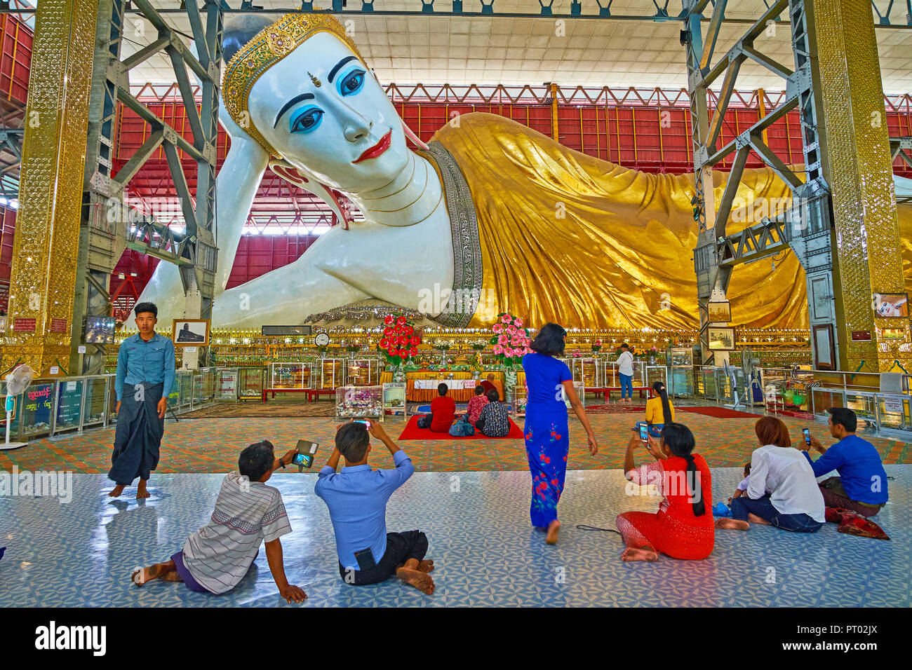 YANGON, MYANMAR - 27. FEBRUAR 2018: die Anbeter der Bilder zu machen, auf dem Boden sitzend vor chaukhtatgyi Buddha Bild, am 27. Februar in Y Stockfoto