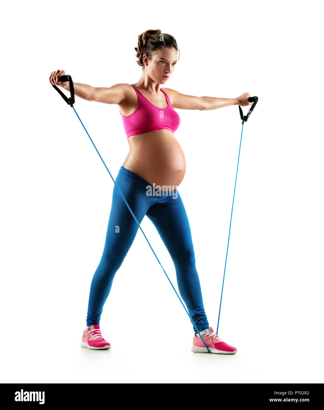 Sportliche schwangere Frau Training mit Expander auf weißem Hintergrund. Konzept des gesunden Lebens Stockfoto