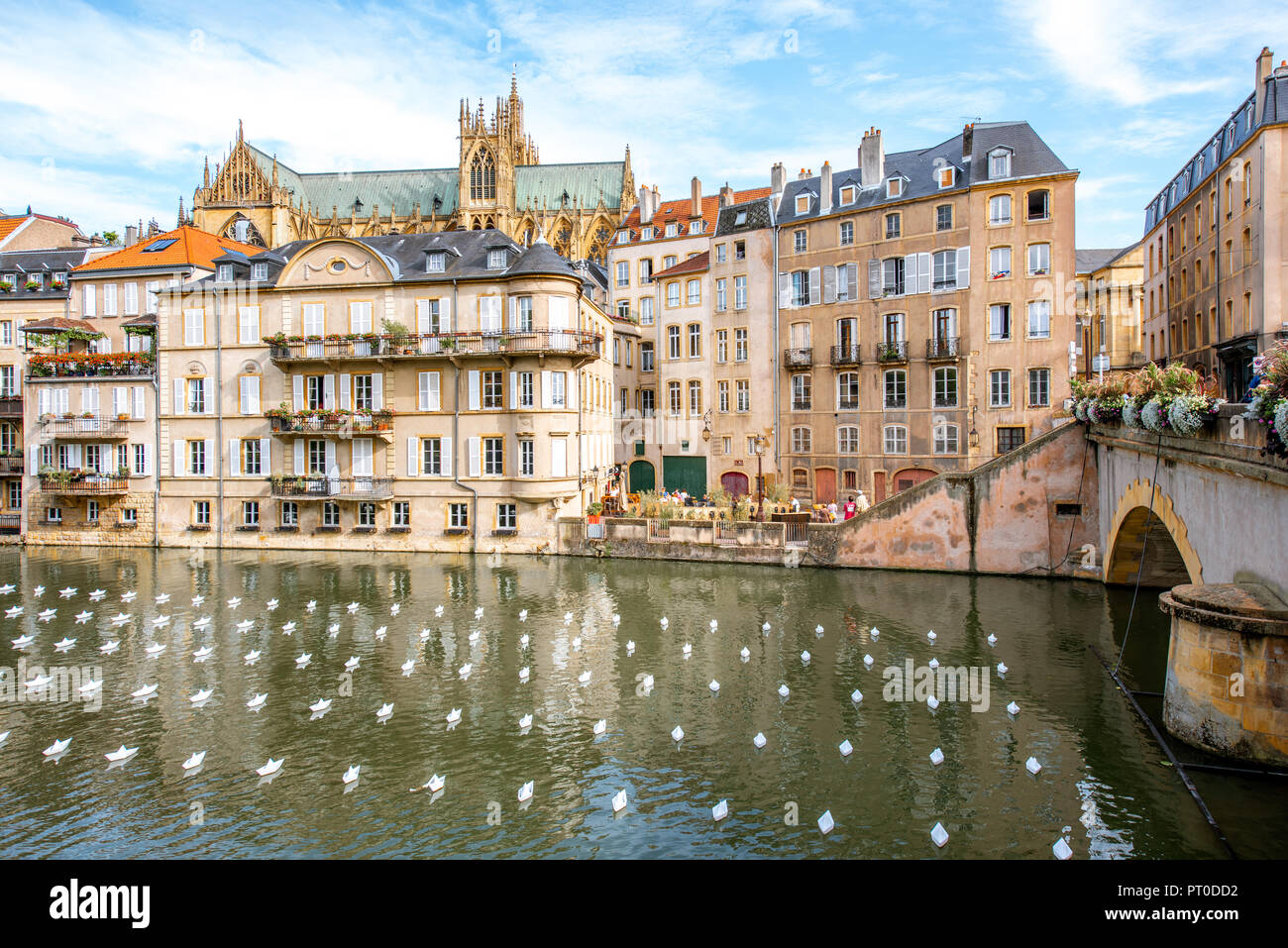 METZ, Frankreich - 26. August 2017: Blick auf den Fluss mit schönen, alten Gebäuden, die Kathedrale auf dem Hintergrund und Papier Boote auf dem Wasser in Metz Stadt in der Region Lothringen in Frankreich Stockfoto