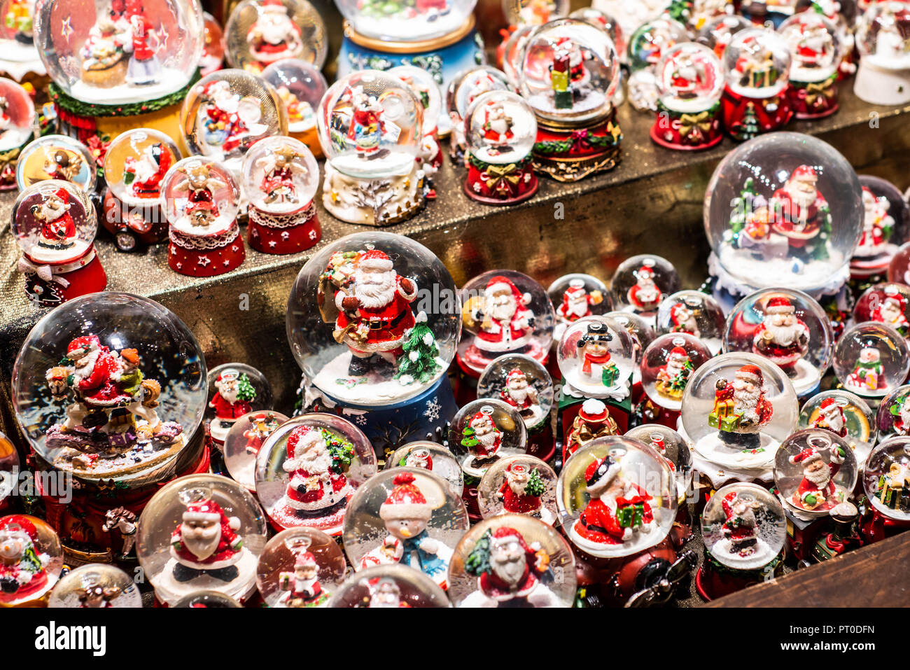 Traditionelle Souvenirs Schneekugeln und Spielzeug Weihnachtsmann Puppen im Europäischen Winter Weihnachtsmarkt Souvenir. Stockfoto