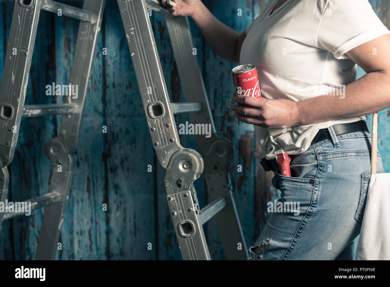 Eine Frau malen eine flache steht neben einer Leiter mit einem Farbroller und Coca Cola Dose Stockfoto