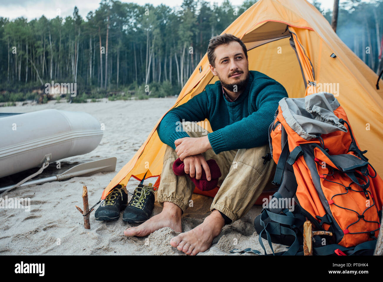 Backpacker vor seinem Zelt am Strand sitzen Stockfoto