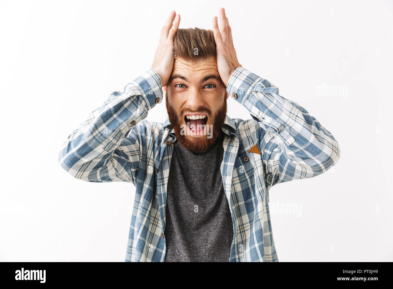 Porträt von einem Genervten junger bärtiger Mann stehend über Weiß isoliert, schreien Stockfoto