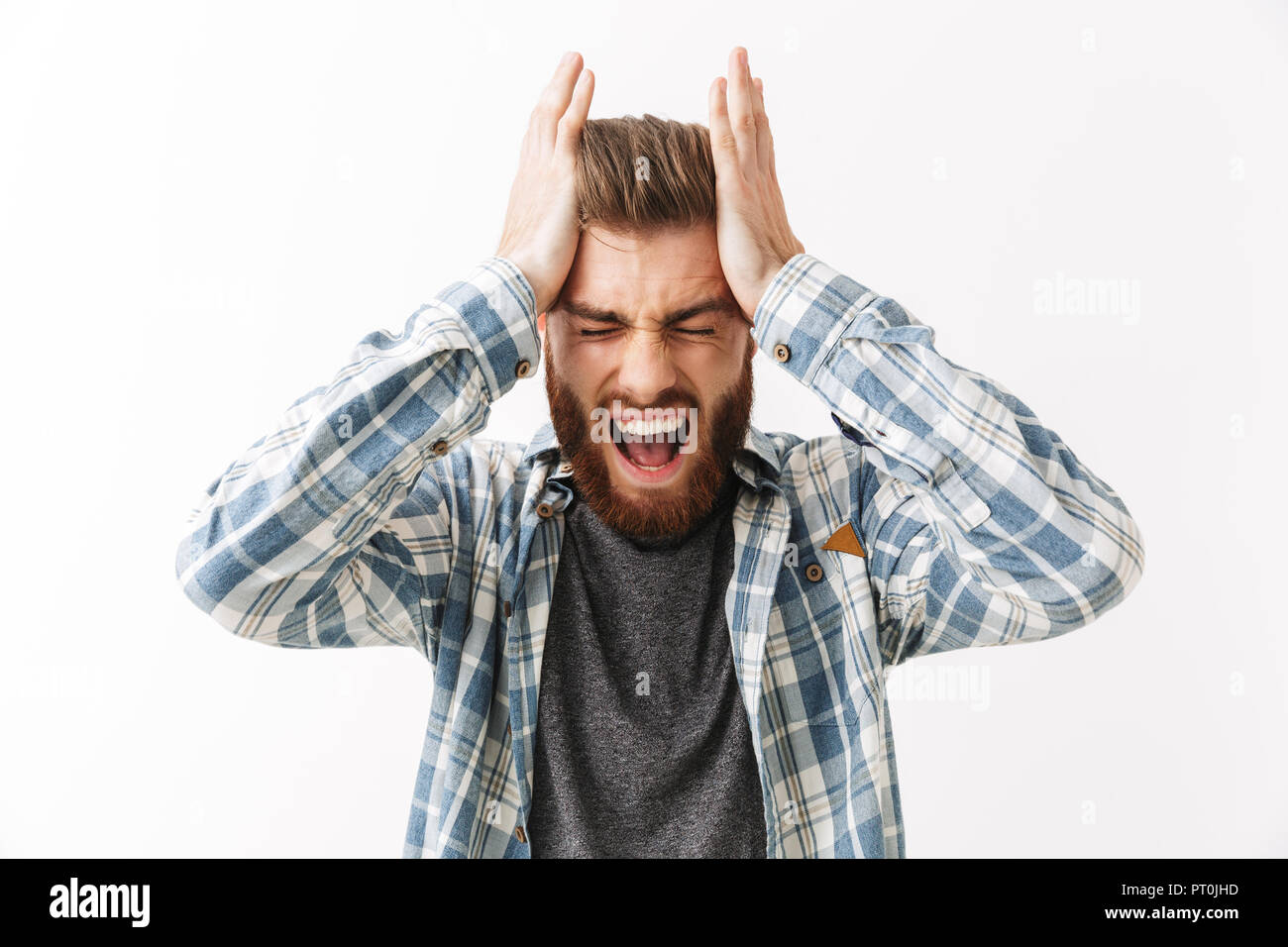 Portrait einer Gereizten junger bärtiger Mann stehend über Weiß isoliert, schreien Stockfoto