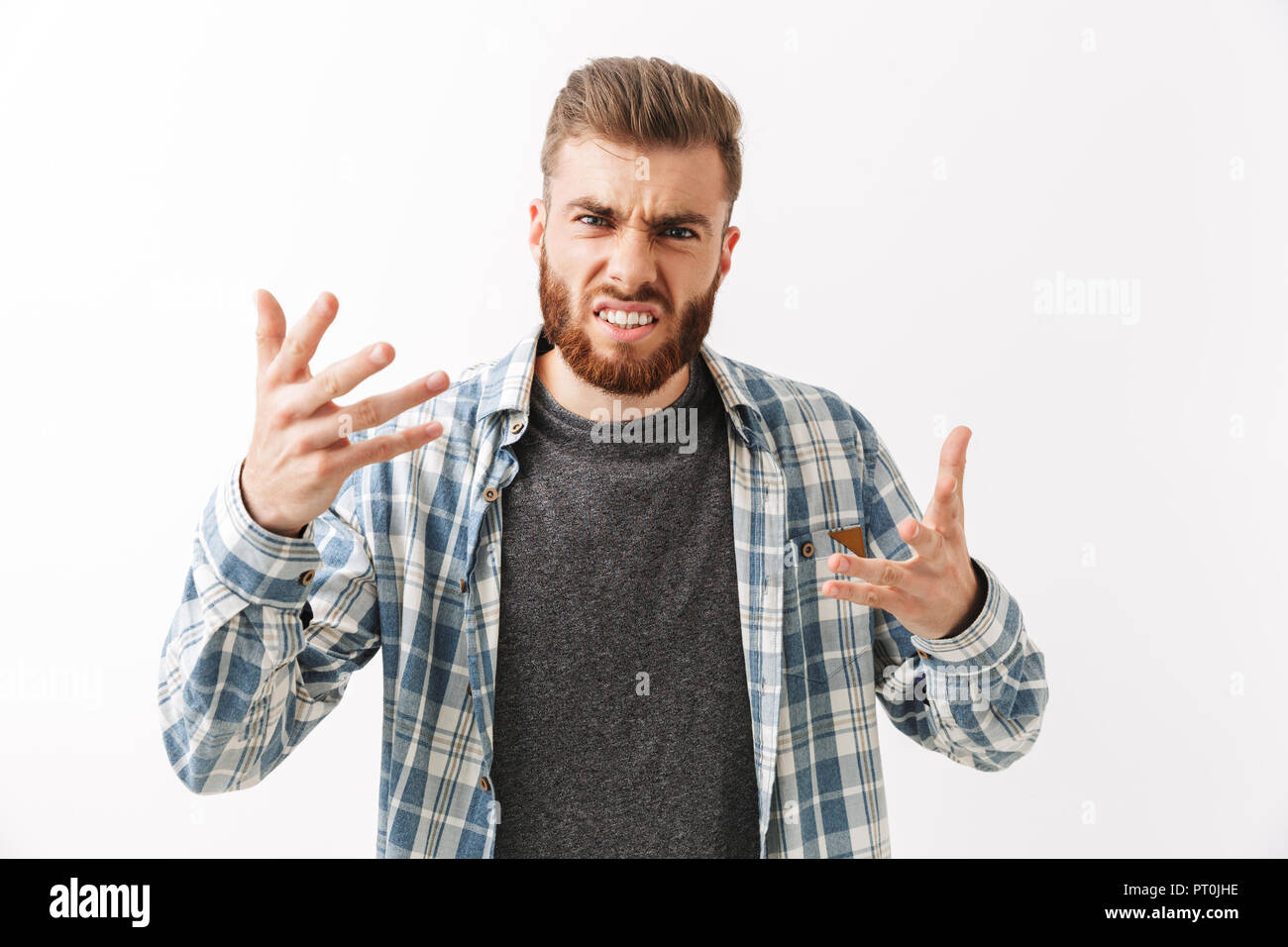 Portrait eines wütenden jungen bärtigen Mann stehend über Weiß isoliert Stockfoto
