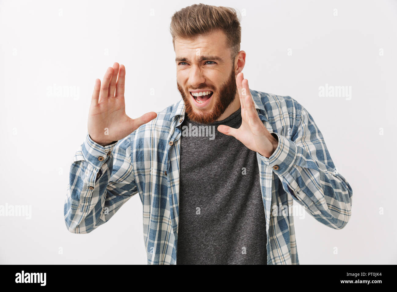 Portrait eines wütenden jungen bärtigen Mann stehend über Weiß isoliert, schreien Stockfoto