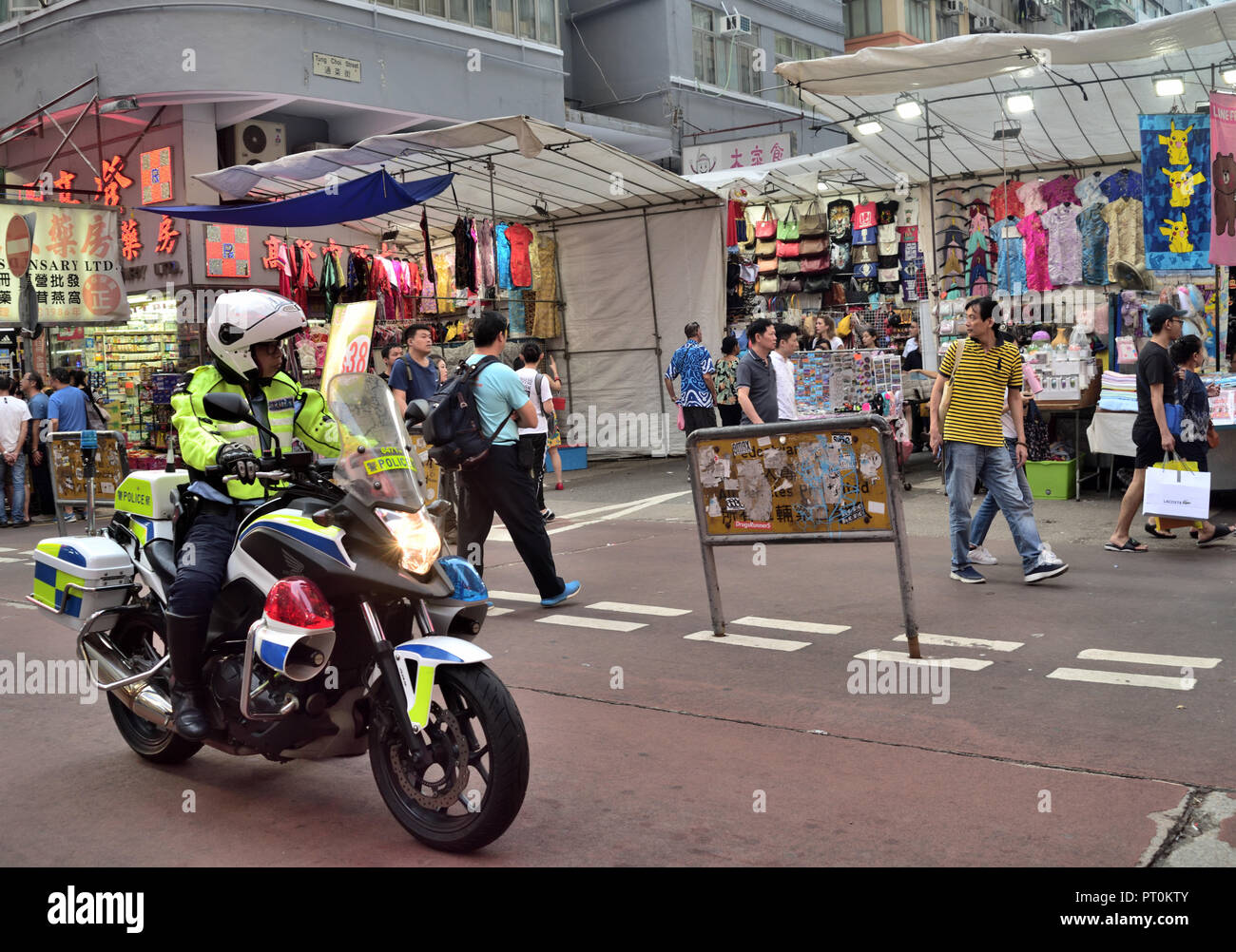 Verkehrspolizei rider Patrouillen entlang der Ladies' Market in Mong Kok, Kowloon, Hong Kong Stockfoto