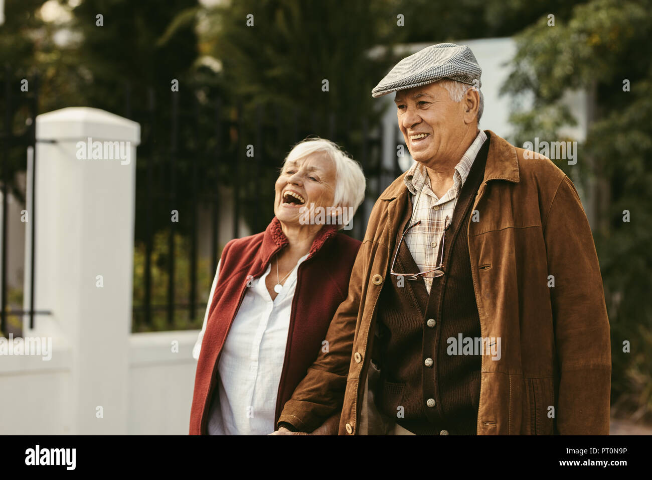 Porträt der alte Mann und Frau tragen warme Kleidung zusammen gehen im Freien und lächelnd. Senior Paar beim zusammen gehen an einem Wintertag. Stockfoto