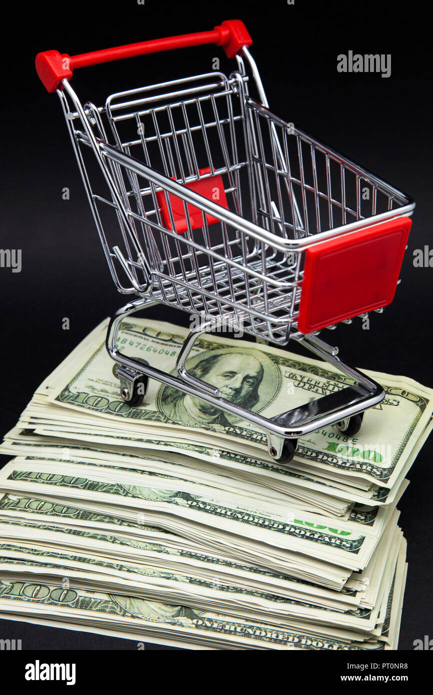 Warenkorb auf Stapel von Banknoten Stockfoto