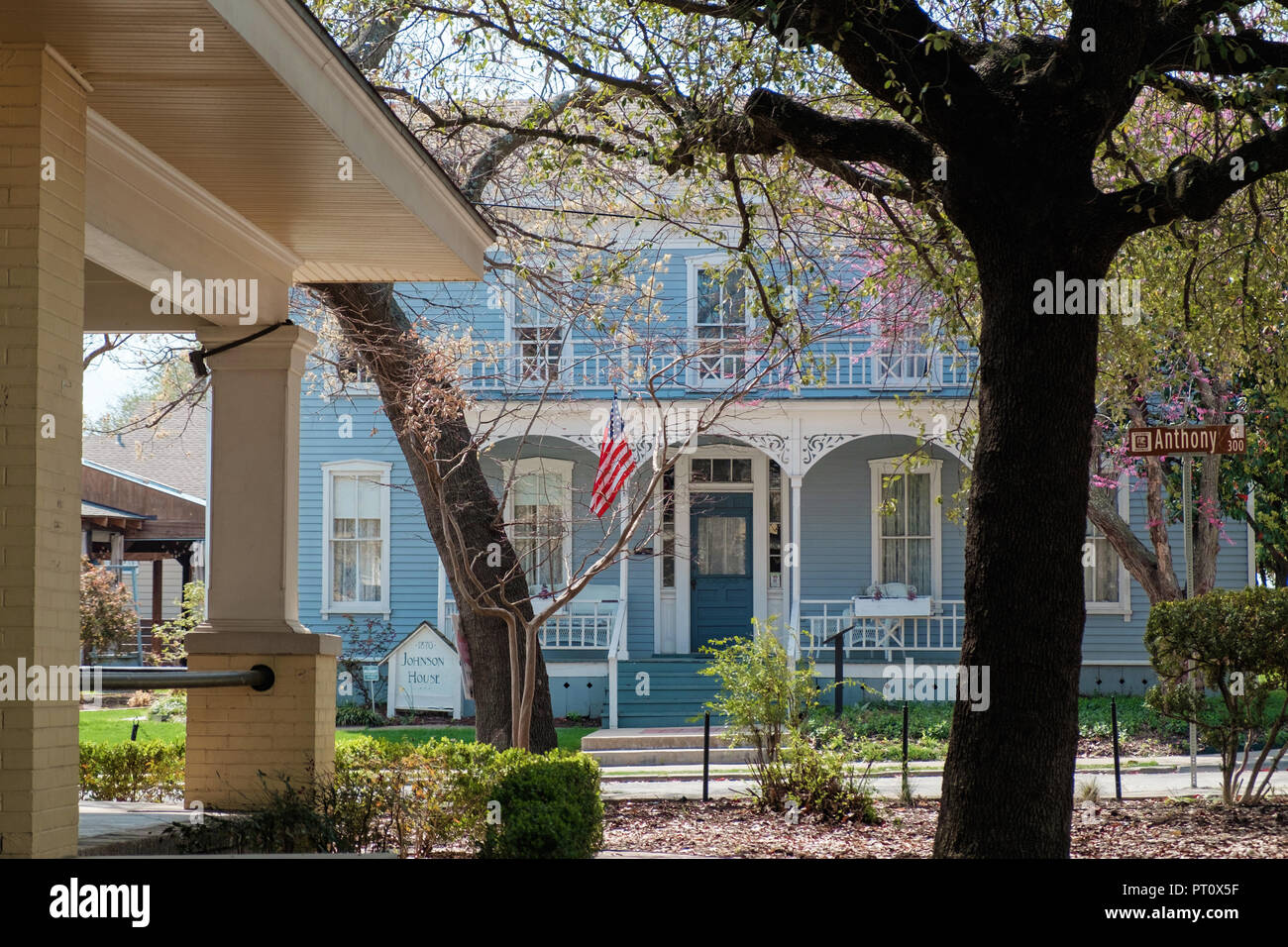 Zwei Geschichte blau geschuppt Haus mit weissen Fensterrahmen Italianate eave Halterungen & American Flag. Die Johnson House, Kastanie Square, McKinney Texas. Stockfoto