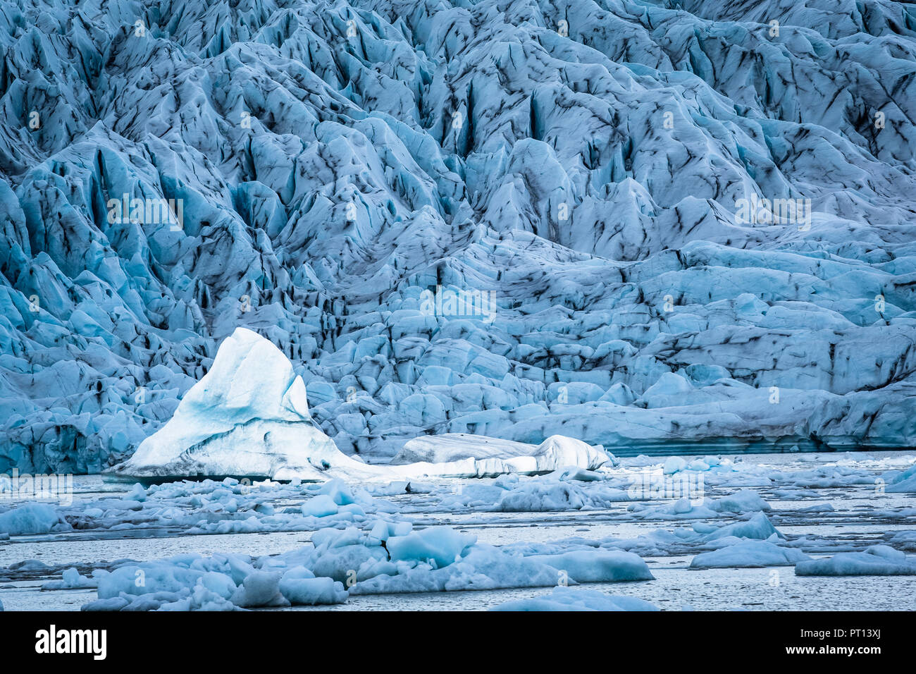 Ein großer Eisberg schweben in der Gletscherlagune Jokulsarlon von, Island, leuchtet durch die Sonne, während der Vordergrund und Hintergrund Gletscher Eisberge sind Alle Stockfoto