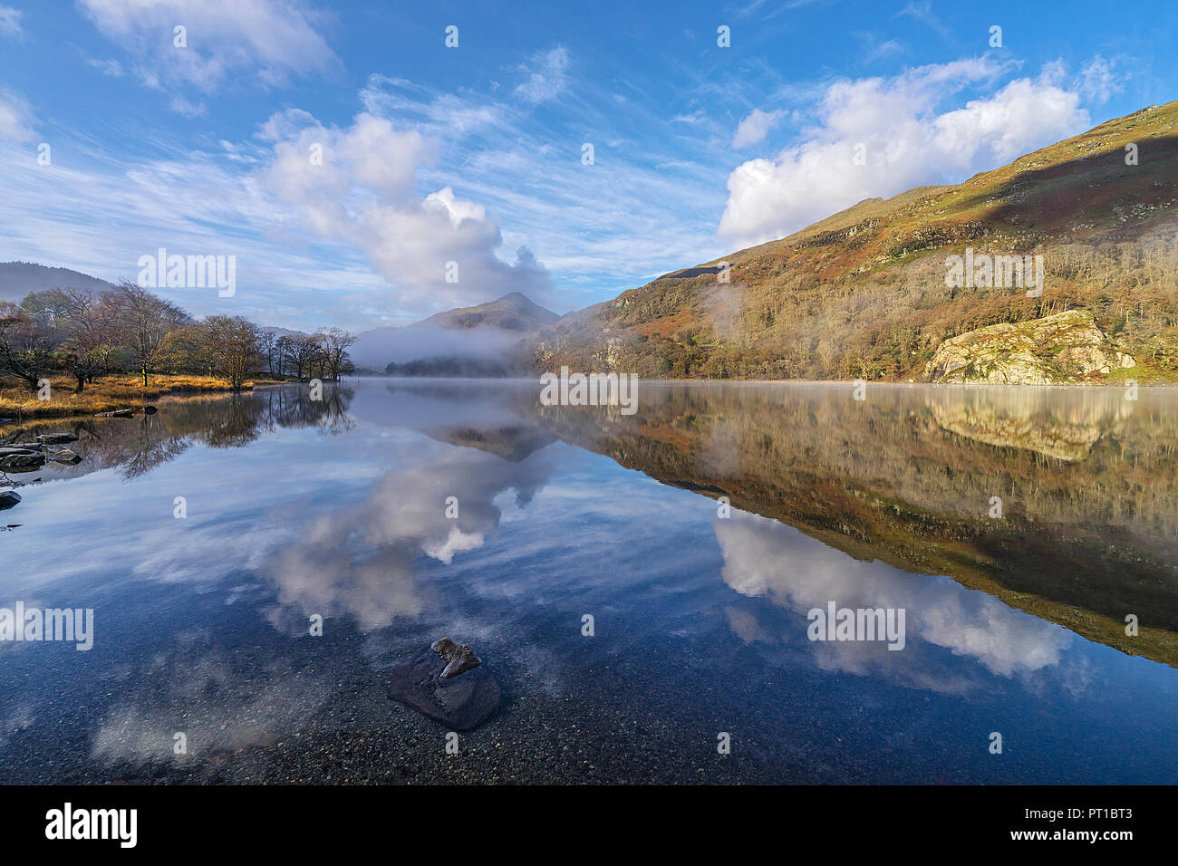 Reflexionen in Llyn Gwynant an einem nebligen Morgen im glaslyn Tal nach Westen mit Yr Aran Berg im Hintergrund Snowdonia National Park Stockfoto