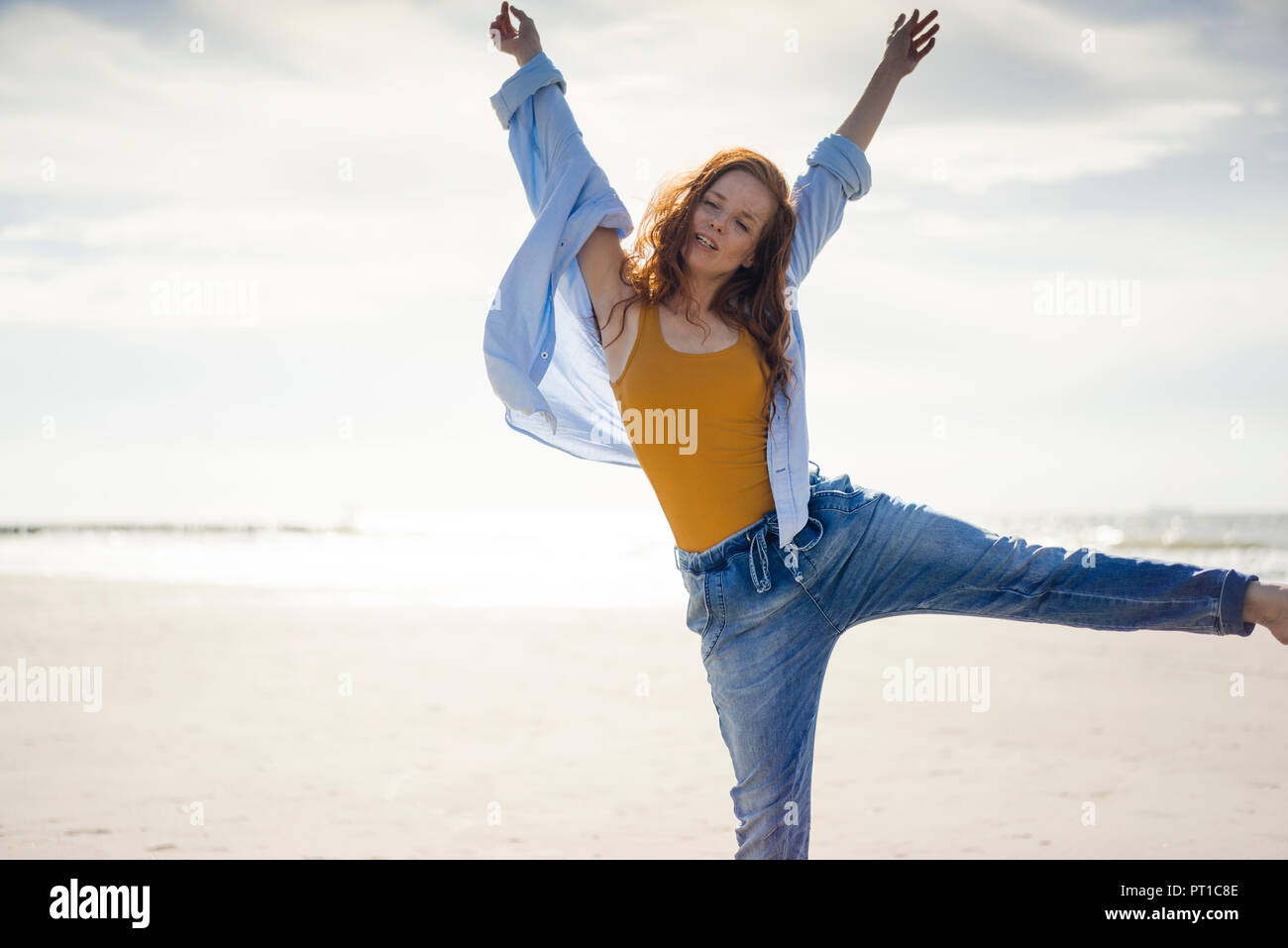 Glückliche Frau Spaß am Strand, springen in die Luft, Stockfoto