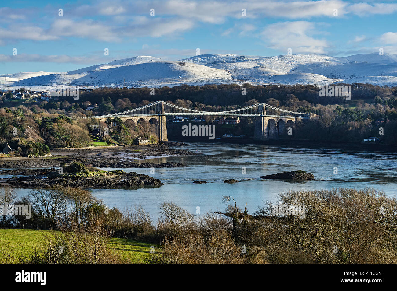 Menai Suspension Bridge, entworfen von Thomas Telford gesehen von Anglesey über die Menai Strait mit Schnee Berge im Hintergrund North Wales U gedeckelt Stockfoto