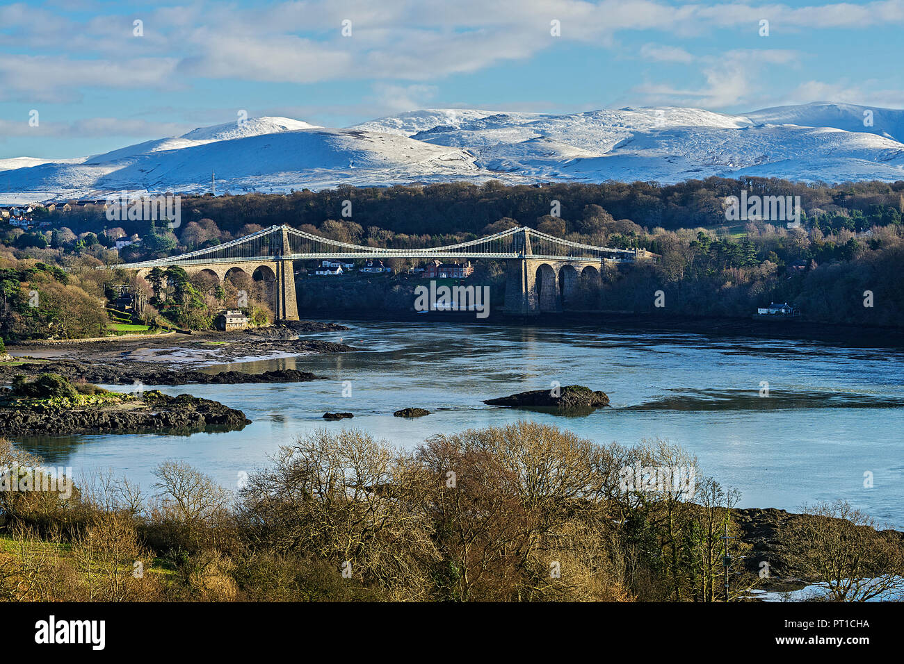 Menai Suspension Bridge, entworfen von Thomas Telford gesehen von Anglesey über die Menai Strait mit Schnee Berge im Hintergrund North Wales U gedeckelt Stockfoto