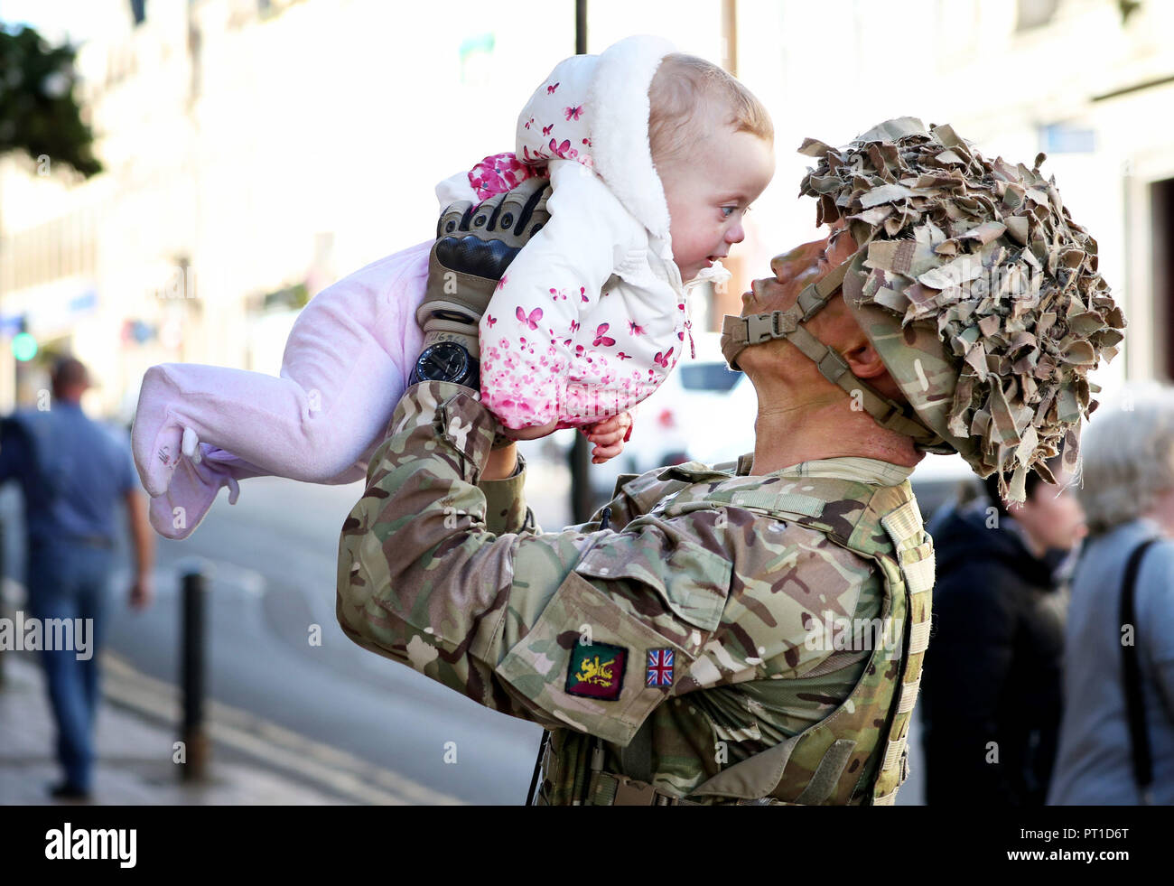 Lance Corporal Anthony Boyle, von Kilmarnock, vereint mit seiner 7 Monate alten Tochter Lucy, nach der Teilnahme an einem homecoming Parade durch Ayr, neben seiner Truppen aus der zweiten Bataillon, das königliche Regiment von Schottland, (2 SCHOTTEN). Stockfoto