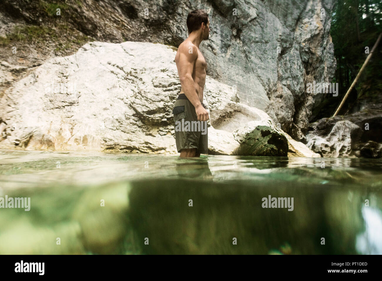 Athletischer Mann in Wasser eines Baches Stockfoto