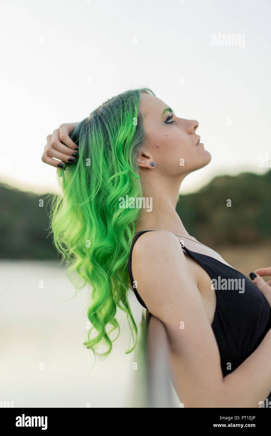 Profil von junge Frau mit gefärbten grüne Haare und Augenbrauen in der Natur Stockfoto