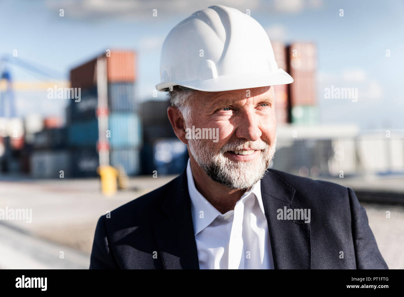 Unternehmer im Cargo Hafen, das Tragen von Helm, Porträt Stockfoto
