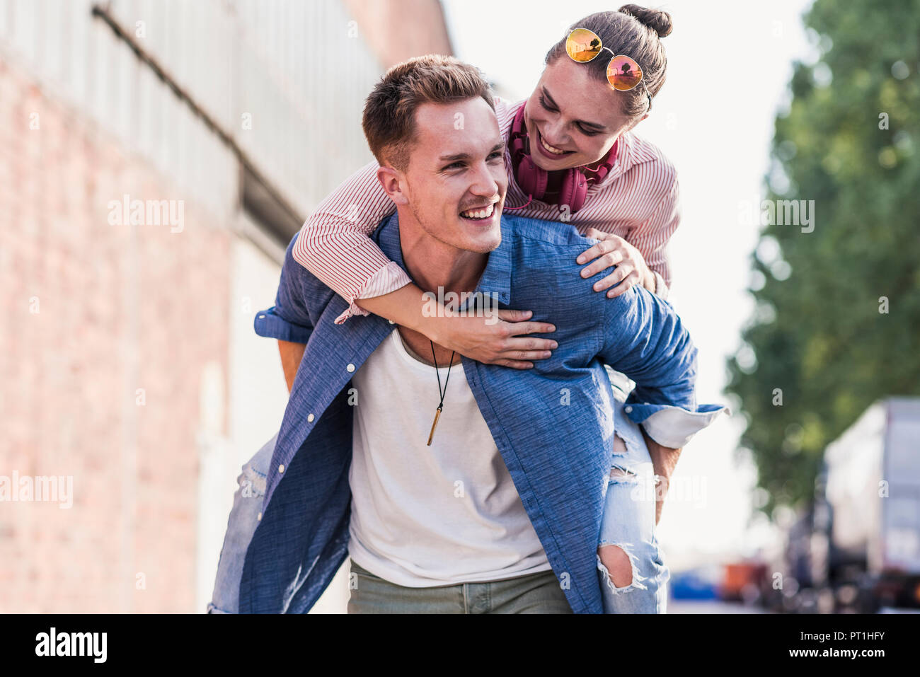 Junger Mann mit Freundin Huckepack Fahrt Stockfoto