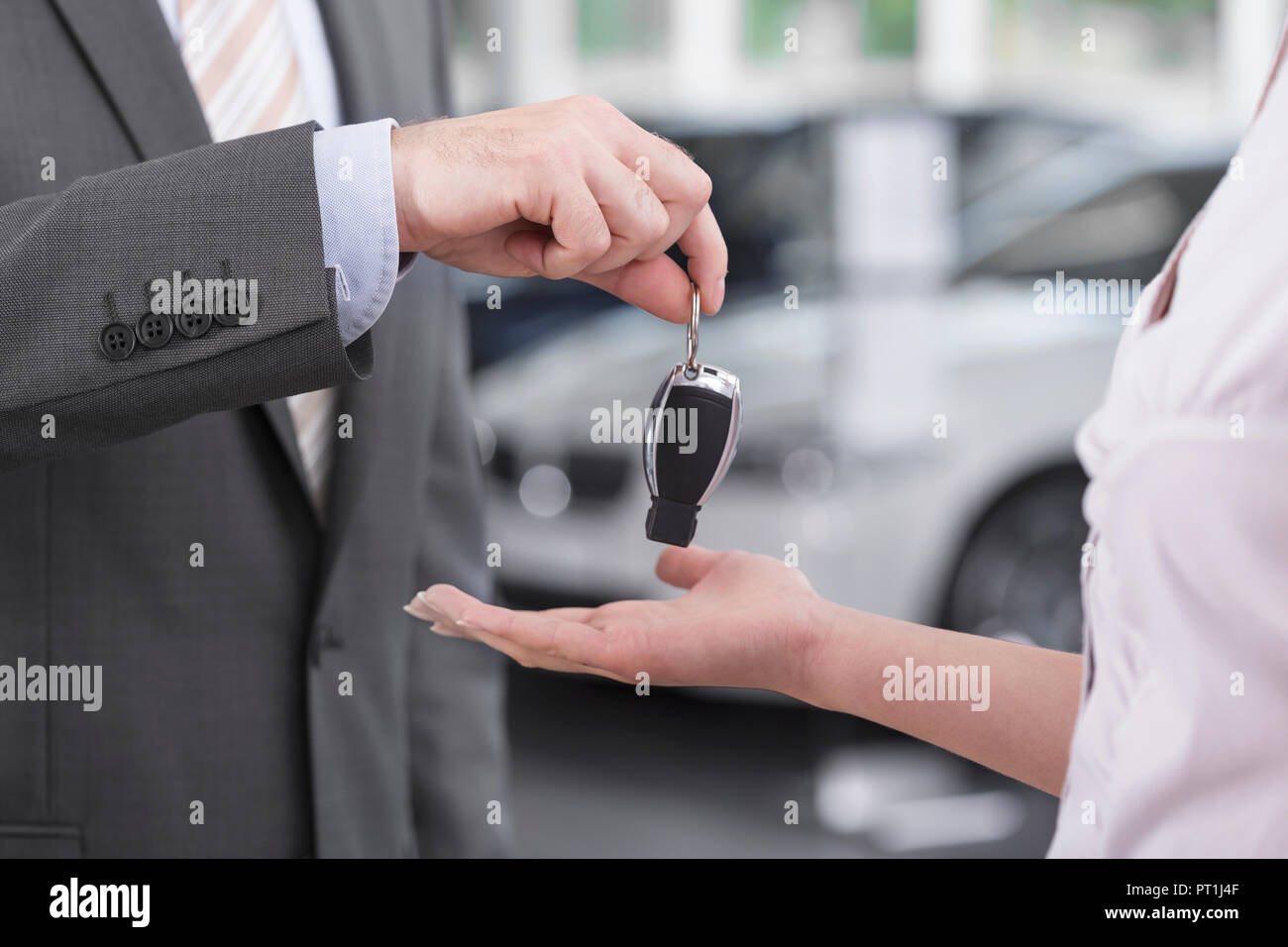 Bei der Kfz-Händler, Verkäufer, die Übergabe der Autoschlüssel an client Stockfoto
