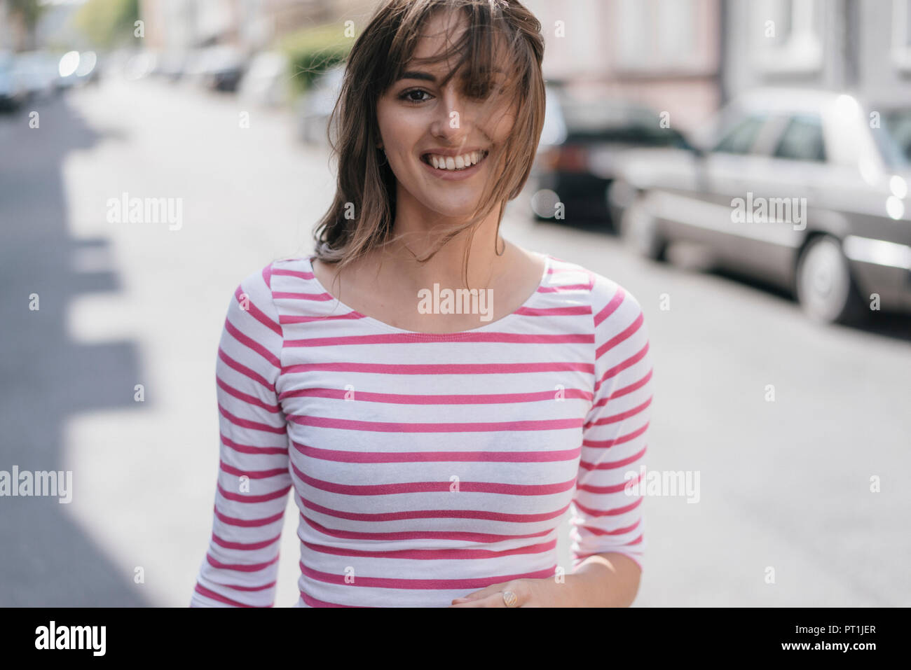 Glückliche junge Frau, die zu Fuß in der Stadt Stockfoto