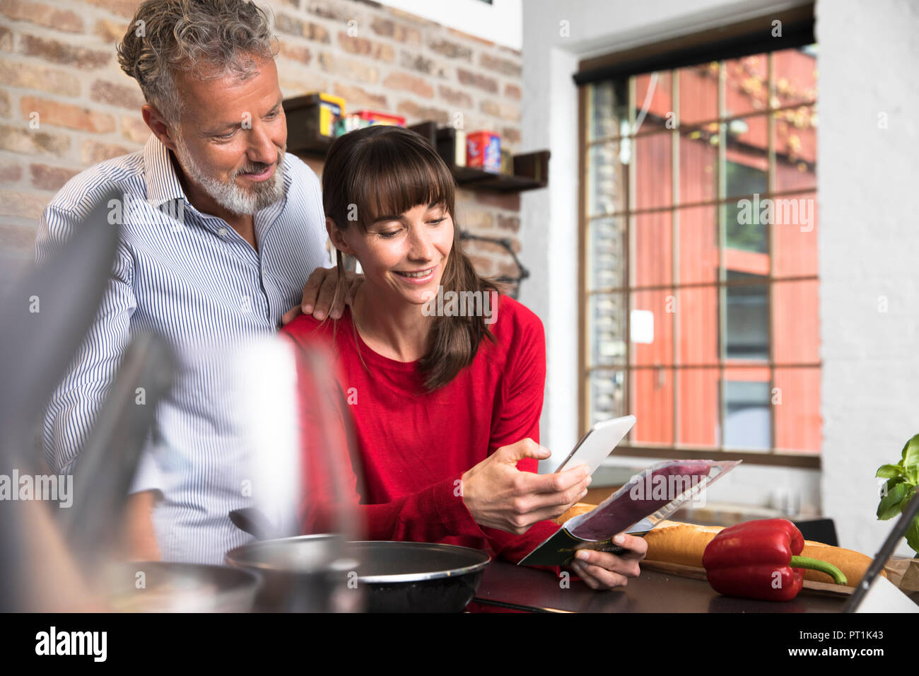 Die Frau in der Küche scannen Produkte mit Ihrem Smartphone, Mann über die Schulter schauen Stockfoto