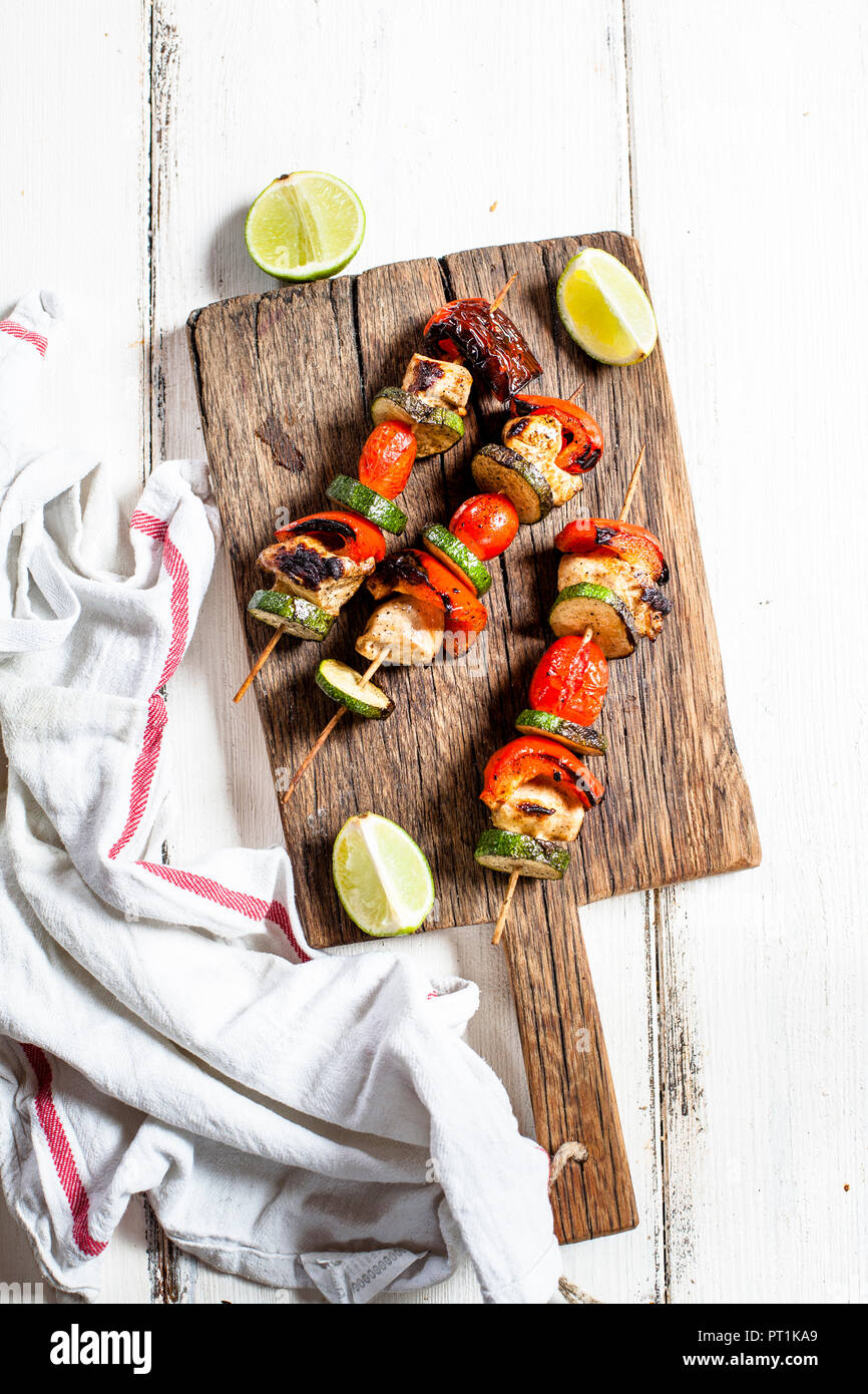 Grill Spieße mit gegrilltem Huhn, Tomaten, Paprika und Zucchini auf Schneidebrett Stockfoto