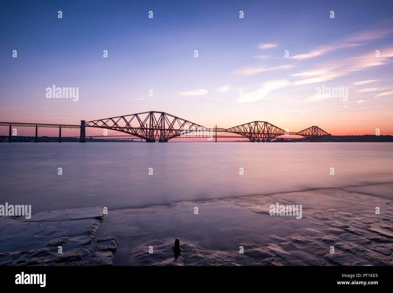 Grossbritannien, Schottland, Fife, Edinburgh, Firth-of-Forth Estuary, Forth Bridge (Eisenbahn) und Forth Road Bridge und Queensferry Kreuzung im Hintergrund, bei Sonnenuntergang Stockfoto