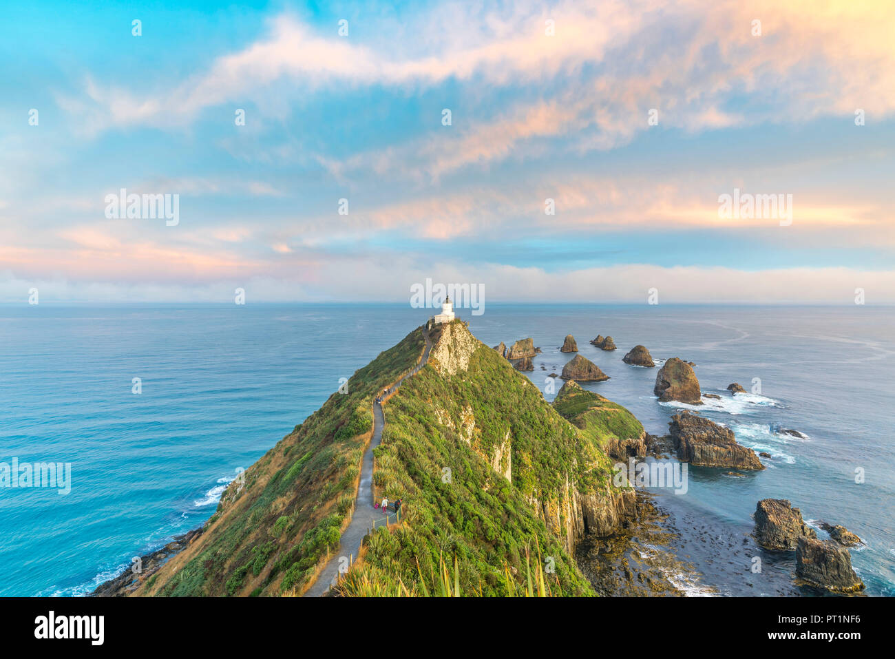 Nugget Point Lighthouse bei Sonnenuntergang von einem erhöhten, Ahuriri Flach, Clutha-distrikt, Region Otago, Südinsel, Neuseeland, Stockfoto