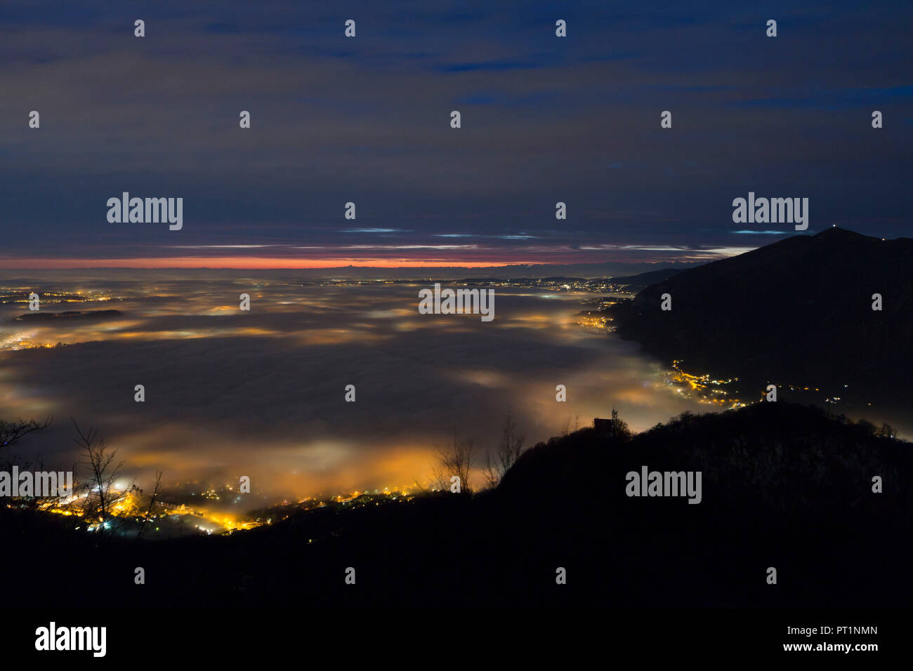 Farbige Nebel über Annone See gesehen von oben Barro Berg in der Dämmerung, Barro Regional Park Mount, Lecco Provinz, Lombardei, Italien Stockfoto