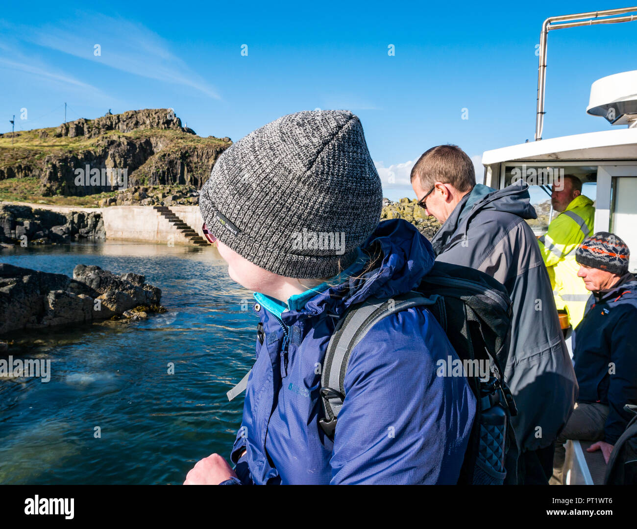 Fidra Island, Firth of Forth, Schottland, Großbritannien, 5. Oktober 2018. Mitarbeiter und Freiwillige der Royal Society for Protection of Birds reisen nach Fidra, um Baummalow abzuhauen, eine nicht-einheimische invasive Pflanze auf den Firth of Forth-Inseln, die gefährdete Papageitaucher daran hindert, Höhlen zu schaffen. Die Ausflüge finden im Frühling und Herbst statt, vor und nach dem Papageitauchennest. Die heutige Reise genoss einen warmen, sonnigen Tag mit blauem Himmel. Das Boot kehrt zurück, um die Gruppe beim Verlassen der Insel abzuholen Stockfoto