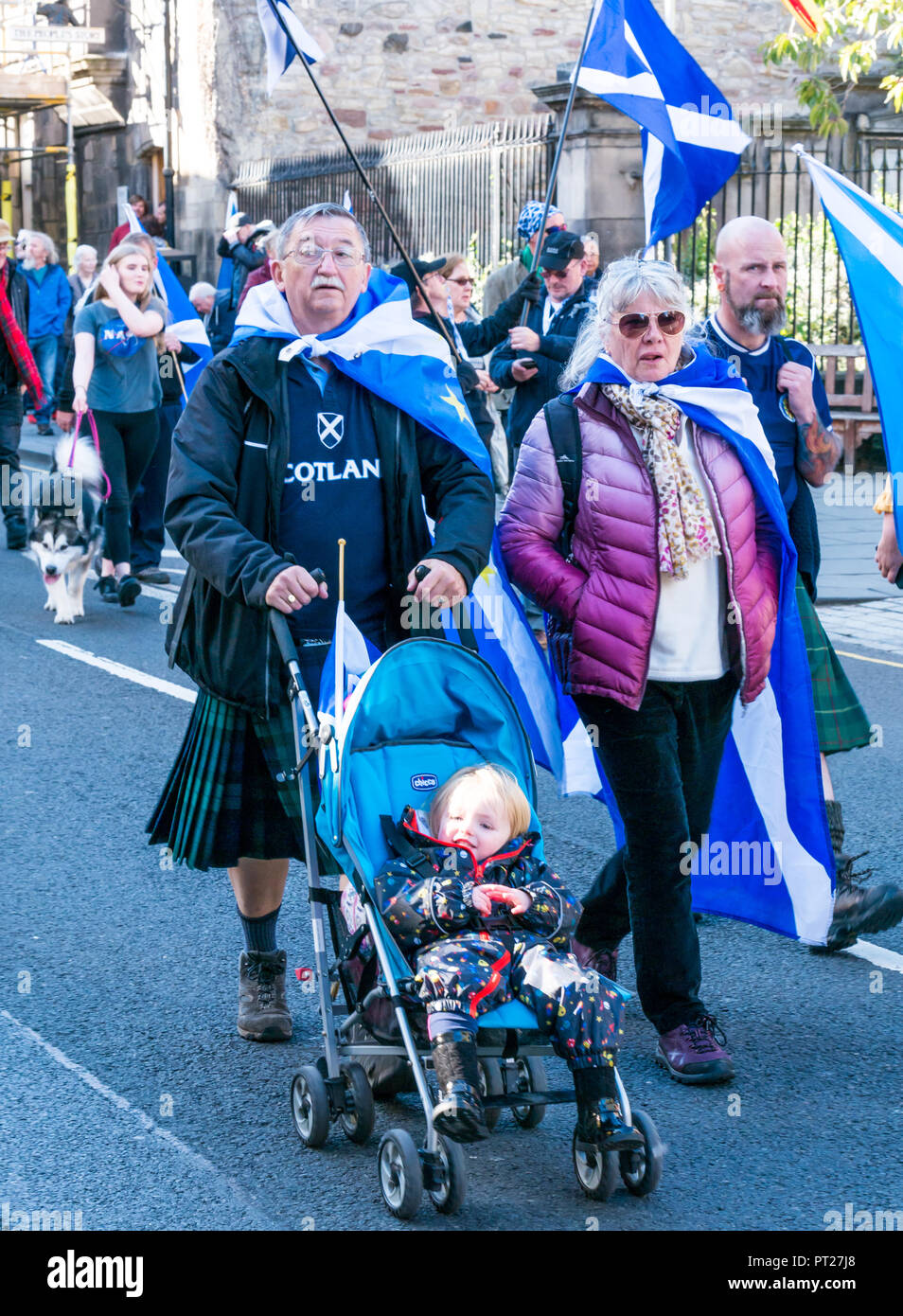 Holyrood Edinburgh, Edinburgh, Schottland, Vereinigtes Königreich, 6. Oktober 2018. Alle unter einem Banner (auob) schottischen März und Rally für Unabhängigkeit, mit Unterstützern auf der Royal Mile, dem Holyrood Park für eine Rallye. AOUB ist ein pro-unabhängigkeit Kampagne für deren Ziel ist es, in regelmäßigen Abständen zu März bis Schottland Unabhängigkeit erreicht. Unabhängigkeit Unterstützer wave saltire Fahnen. Ein älterer Mann und Frau auf dem März push ein junges Kind in einem Buggy Stockfoto