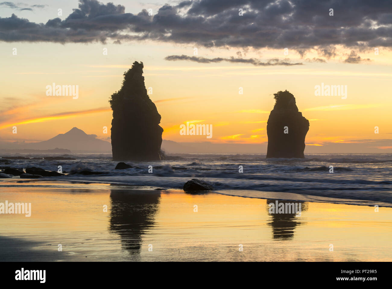 Sonnenuntergang an der Drei Schwestern, mit Mount Taranaki im Hintergrund, Tongaporutu, New Plymouth Bezirk, Taranaki region, North Island, Neuseeland, Stockfoto