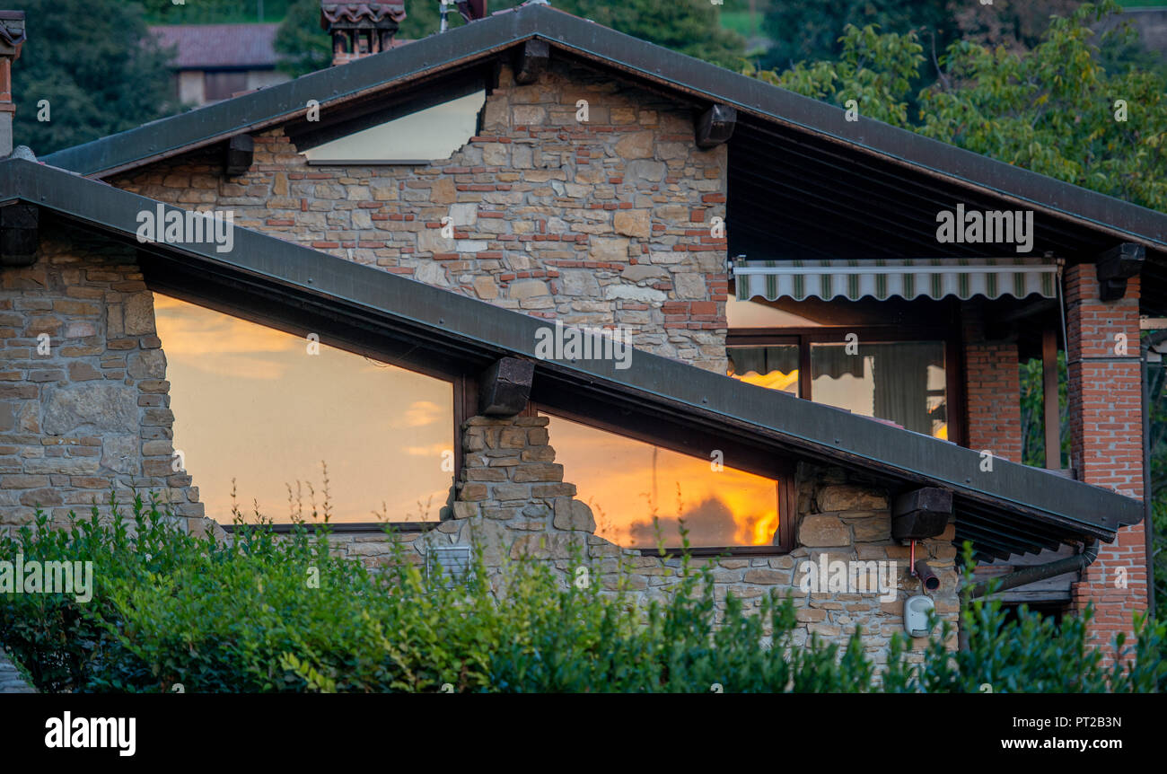 Renoviertes Haus eine Sonne in den Fenstern reflektierende Stockfoto