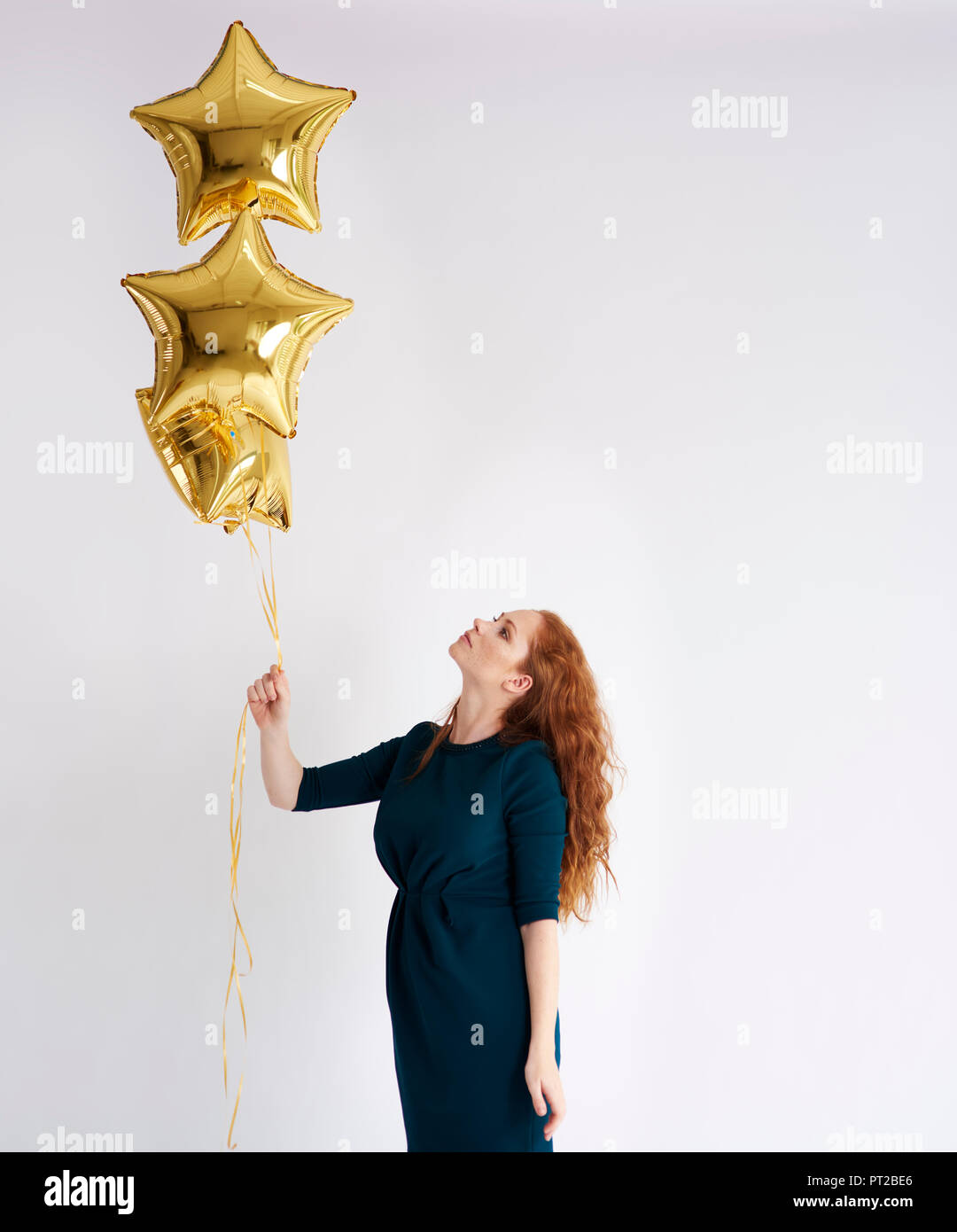 Junge Frau mit drei golden star-förmige Ballons Stockfoto