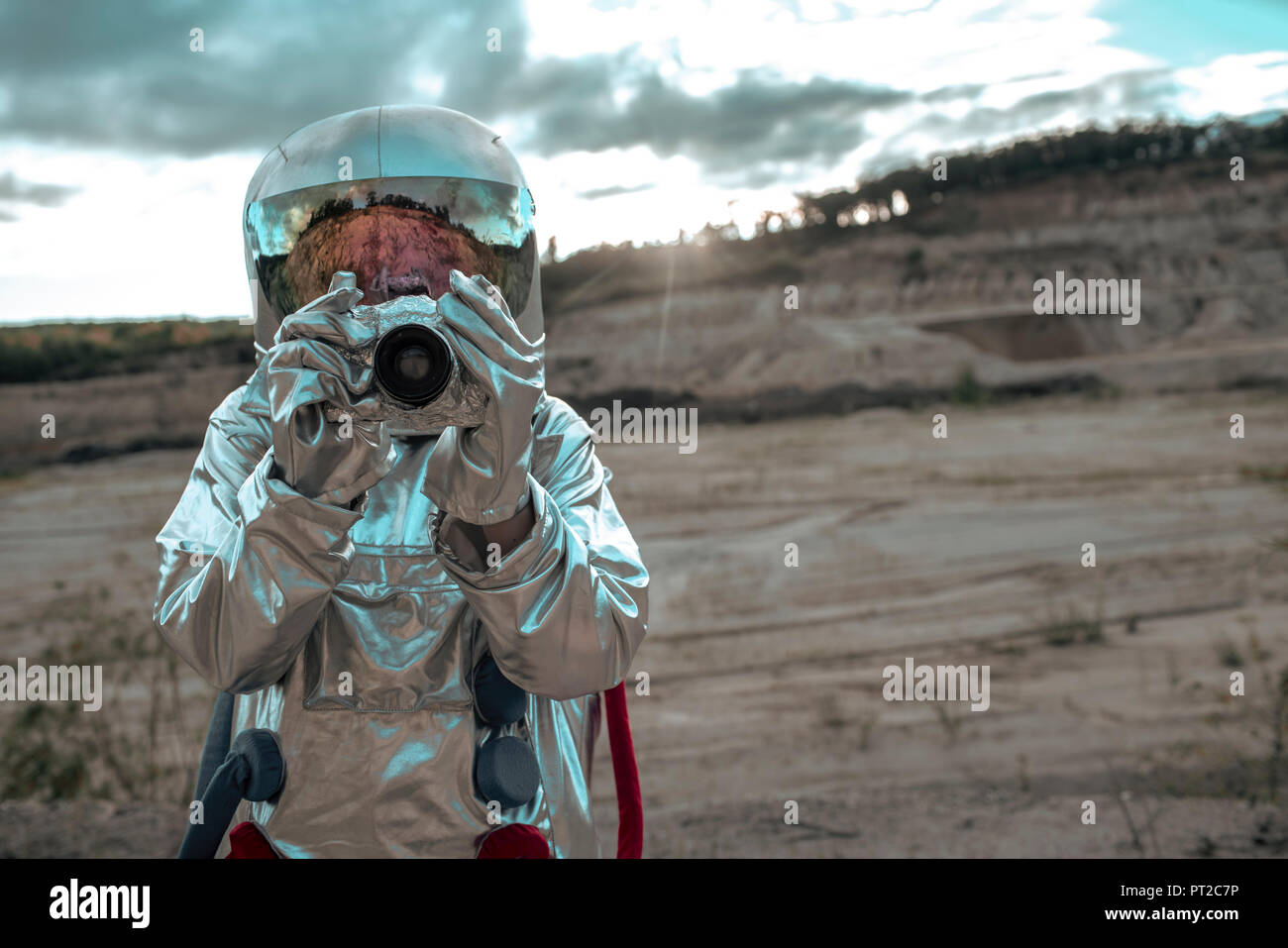 Spaceman auf namenlosen Planeten Aufnehmen von Bildern mit der Kamera Stockfoto